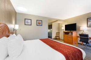 a hotel room with a bed and a flat screen tv at Comfort Inn University Center in Fairfax