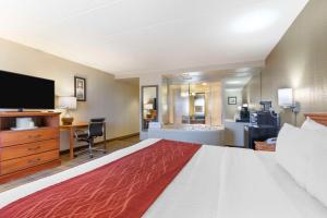 a hotel room with a large bed and a television at Comfort Inn University Center in Fairfax