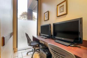 a desk with a computer monitor and a keyboard at Comfort Inn University Center in Fairfax