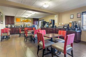 a restaurant with tables and chairs and a kitchen at Comfort Inn University Center in Fairfax