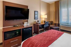 a hotel room with a bed and a flat screen tv at Comfort Inn Great Falls South in Great Falls