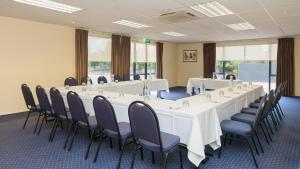 a conference room with a long table and chairs at Heartland Hotel Auckland Airport in Auckland