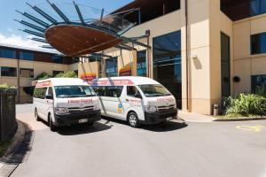 two vans parked in front of a building at Heartland Hotel Auckland Airport in Auckland