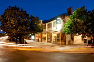 un edificio en la esquina de una calle por la noche en Cobb & Co Court Boutique Hotel, en Mudgee