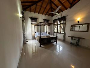 a bedroom with a bed in the middle of a room at Curve Hiri in Dickwella