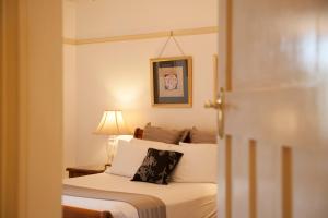 a bedroom with a bed with a pillow on it at Cobb & Co Court Boutique Hotel in Mudgee