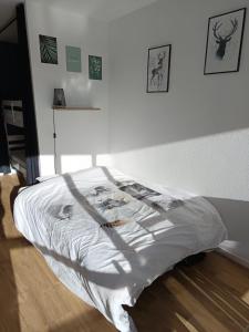 un letto con piumone bianco in una camera da letto di Cosy studio 25 m2 orienté sud entièrement rénové a Prénatier