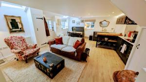 a living room with a couch and two chairs at Plum Cottage Somerset in Wells