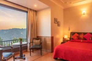 a bedroom with a red bed and a large window at The Horizon Villa Dharamshala in Dharmsala