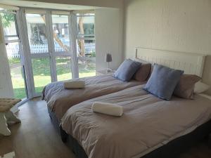 a large bed with two pillows on it in a bedroom at 4250 River Club in Plettenberg Bay