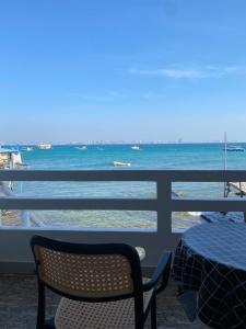 a table and a chair on a balcony with the ocean at วินเนอร์วิว เกาะล้าน in Ko Larn
