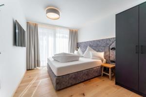 sypialnia z łóżkiem i dużym oknem w obiekcie Adler Resort w Saalbach Hinterglemm +37 zdjęć