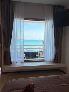 a bedroom with a window with a view of the ocean at วินเนอร์วิว เกาะล้าน in Ko Larn