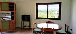 a dining room with a table and a window at Casa Vacanza Casarcobaleno in Ardore Marina
