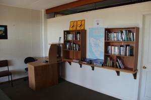 an office with a desk and book shelves with books at Burnie Ocean View Motel and Caravan Park in Burnie