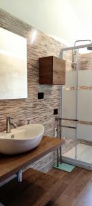 a bathroom with a white sink on a wooden counter at Casa Vacanza Casarcobaleno in Ardore Marina