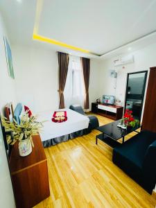 a hotel room with a bed and a living room at SAPHIA Hotel Hue in Hue