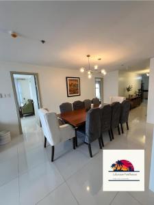 a dining room and living room with a table and chairs at Lakeview Penthouse by Timothy in Tagaytay