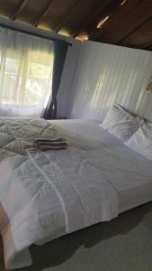 ein großes weißes Bett in einem Zimmer mit Fenster in der Unterkunft Datu Villa Sembalun in Sembalun Lawang + 15 Fotos