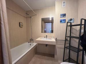 Un baño con bañera, lavabo y espejo. en SN Vista Nevada Suites, en Sierra Nevada 16 fotos más