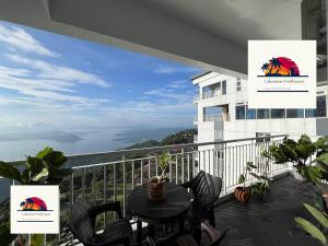 a balcony with a table and chairs and a view at Lakeview Penthouse by Timothy in Tagaytay