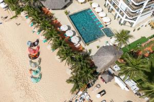 an overhead view of a beach with palm trees and a swimming pool at Mana Mui Ne Beach Resort & Spa in Mui Ne