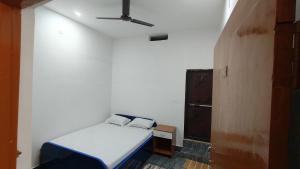 una camera da letto con un letto e un ventilatore a soffitto di Hotel M P Anand Palace a Gaya