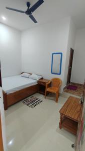 una camera da letto con un letto, una scrivania e una sedia di Hotel M P Anand Palace a Gaya
