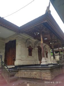 a building with a porch and a large entrance at Men Sari Homestay in Tabanan