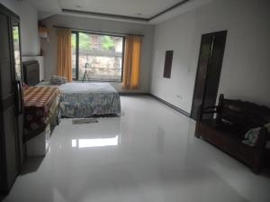 a large room with a bed and a window at Men Sari Homestay in Tabanan
