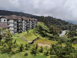 an apartment building on a hill with a river at Cameron Greenhill Apartment in Cameron Highlands