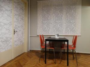 a table and chairs in a room with a wall at Exarchia - Room in shared apartment in Athens +31 photos