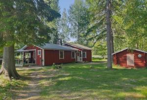 a red cabin in the middle of a forest at Vuonamo - Summer cottage in Keitele