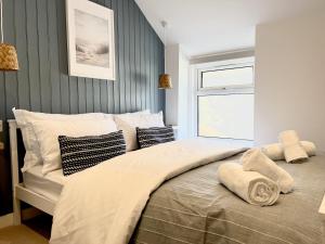 1 dormitorio con 1 cama grande con almohadas y ventana en 2 Edward Street, en Llandudno
