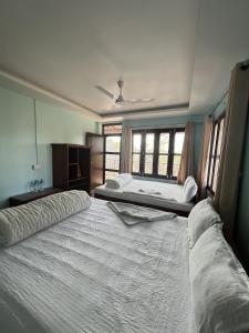 索拉哈Sauraha Guest House的一间卧室设有两张床和两个窗户。