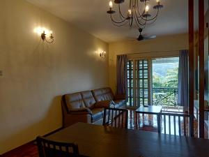 a living room with a couch and a table at Cameron Greenhill Apartment in Cameron Highlands