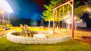 a fire pit in the middle of a yard at night at Shantai Farms in Talegaon Dābhāde