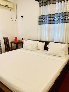 a large white bed in a room with a window at Rich Living Resort in Tangalle