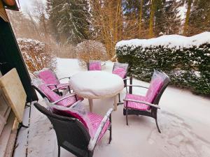 a table and chairs covered in snow on a patio at Winterberg Appartement 6 Pers am Skilift größten Skigebiets, ruhige Garten im Wald, gemütlichen Après-Ski-Cafés Restaurants zu Fuß erreichbar, Parkplatz, Schwimmbad, Sauna, Relaxraum, Buchbaren Massages Wellness Der Brabander, Darts Tischtennis-Fußball in Winterberg