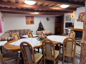 una sala da pranzo con tavolo, sedie e albero di Natale di Zázrivský Dvor - Chata pod Rozsutcom, Wellness, Self Check-In, 3 bedrooms, 2 bathrooms a Zázrivá