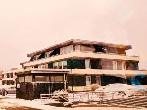 a tall building with a car parked in front of it at Winterberg Appartement 6 Pers am Skilift größten Skigebiets, ruhige Garten im Wald, gemütlichen Après-Ski-Cafés Restaurants zu Fuß erreichbar, Parkplatz, Schwimmbad, Sauna, Relaxraum, Buchbaren Massages Wellness Der Brabander, Darts Tischtennis-Fußball in Winterberg +70 photos