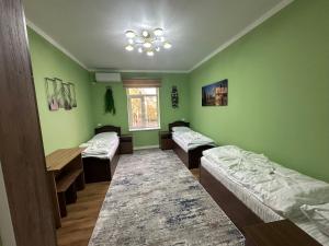 ein Zimmer mit drei Betten und einem Fenster in der Unterkunft Registan view apartment in Samarkand