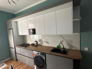 eine Küche mit weißen Schränken und einer Spüle in der Unterkunft Registan view apartment in Samarkand