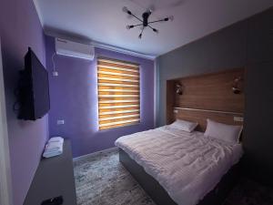 ein Schlafzimmer mit Bett und Deckenventilator in der Unterkunft Registan view apartment in Samarkand + 2 Fotos