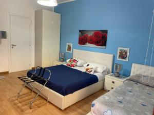 una camera da letto con un letto con una parete blu di Medea rooms palermo centro a Palermo