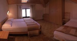 een hotelkamer met twee bedden en een raam bij Altipiani Trentini in Lavarone