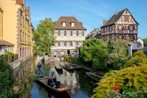 a group of people riding in boats down a river at Au théâtre in Colmar