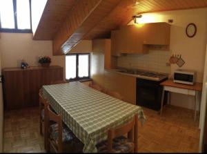 een keuken met een tafel en een keuken met een fornuis bij Altipiani Trentini in Lavarone