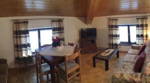 een woonkamer met een tafel en een bank bij Altipiani Trentini in Lavarone