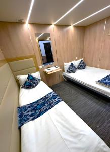 two beds in a small room with a mirror at Qo'noq Tashkent Airport Hotel Sleep Lounge & Showers, Terminal 2 - TRANSIT ONLY in Tashkent